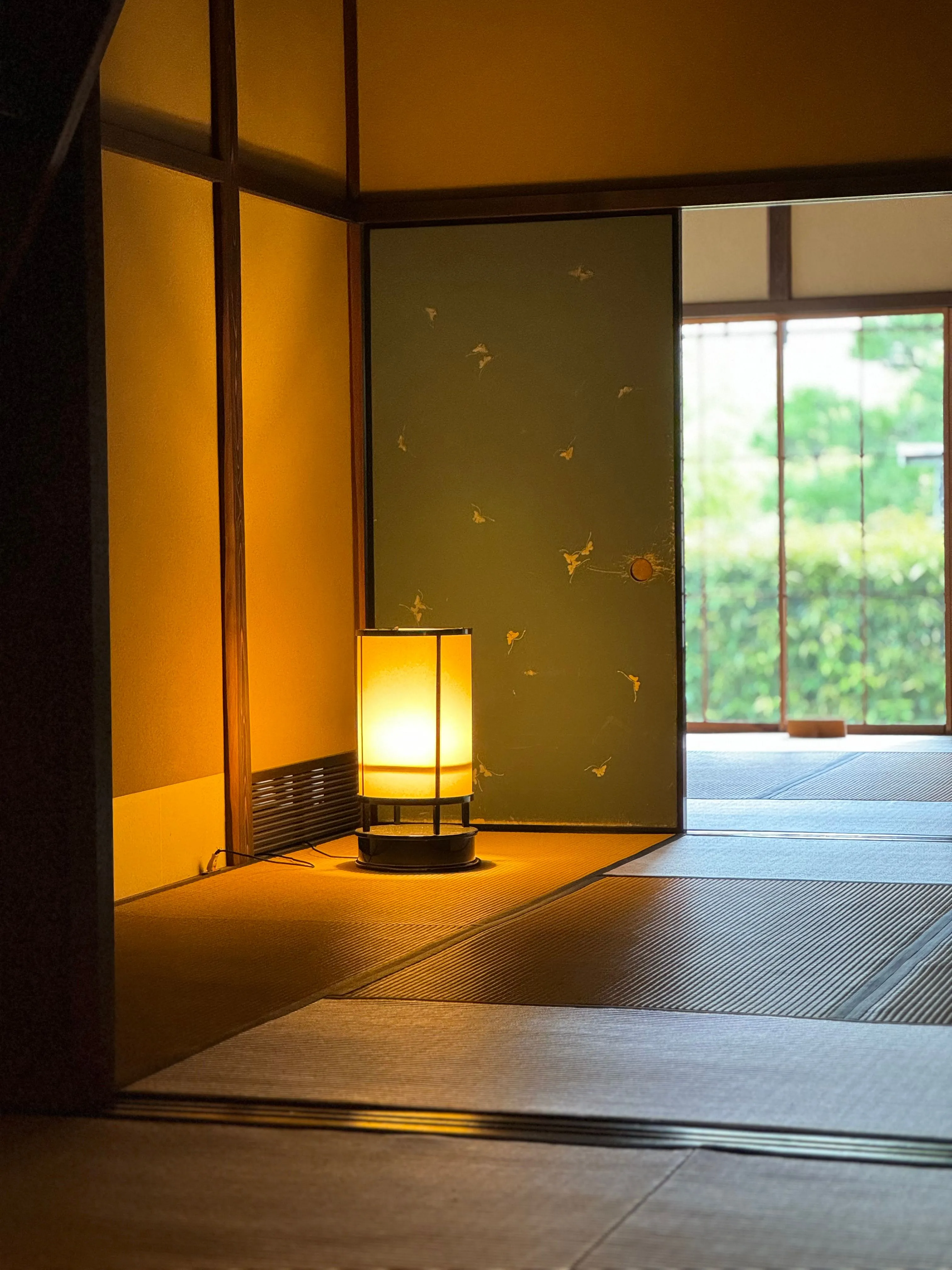 A softly lit traditional Japanese room with tatami flooring