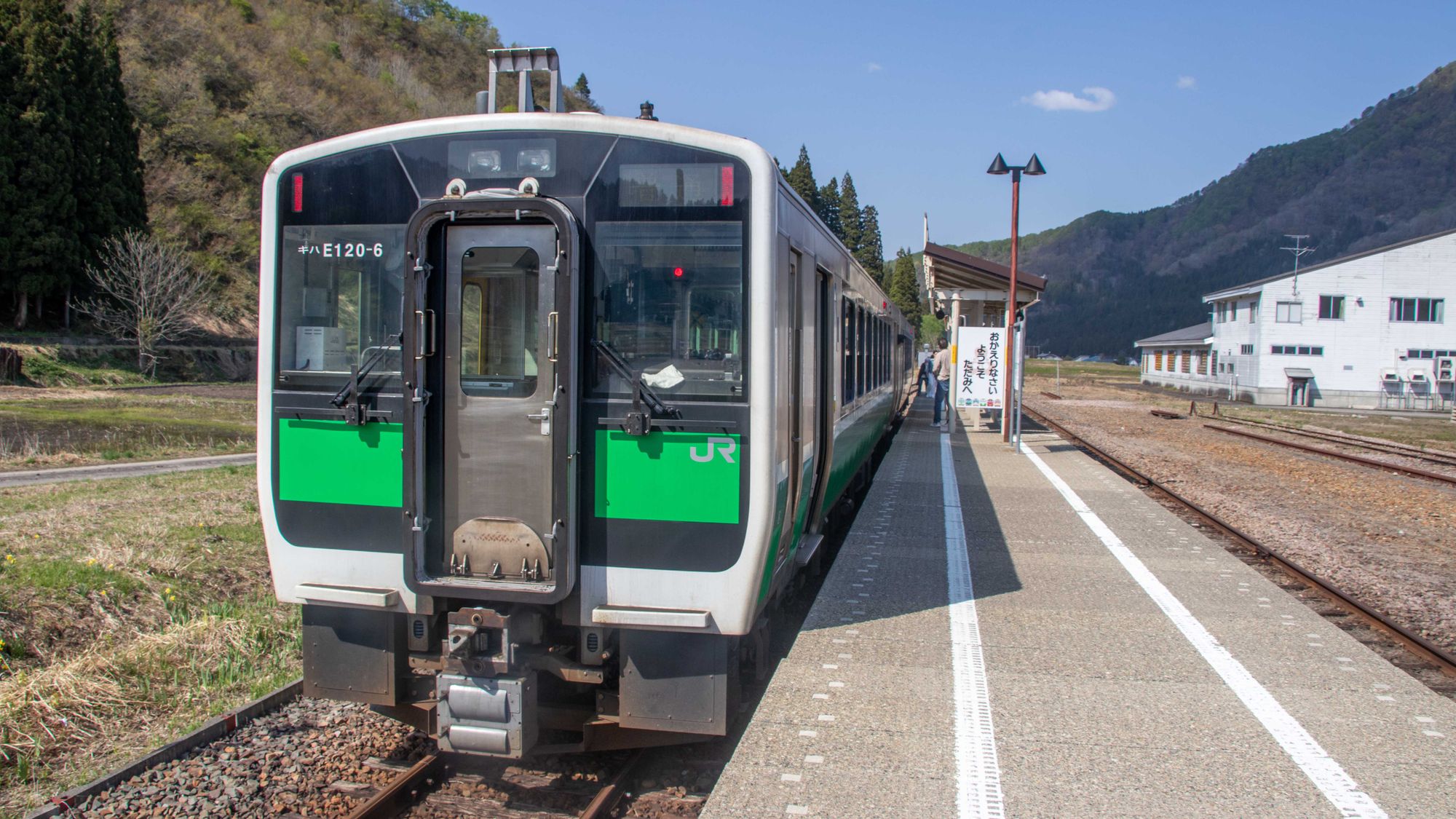 A local JR train waiting at a rural mountain station in Japan